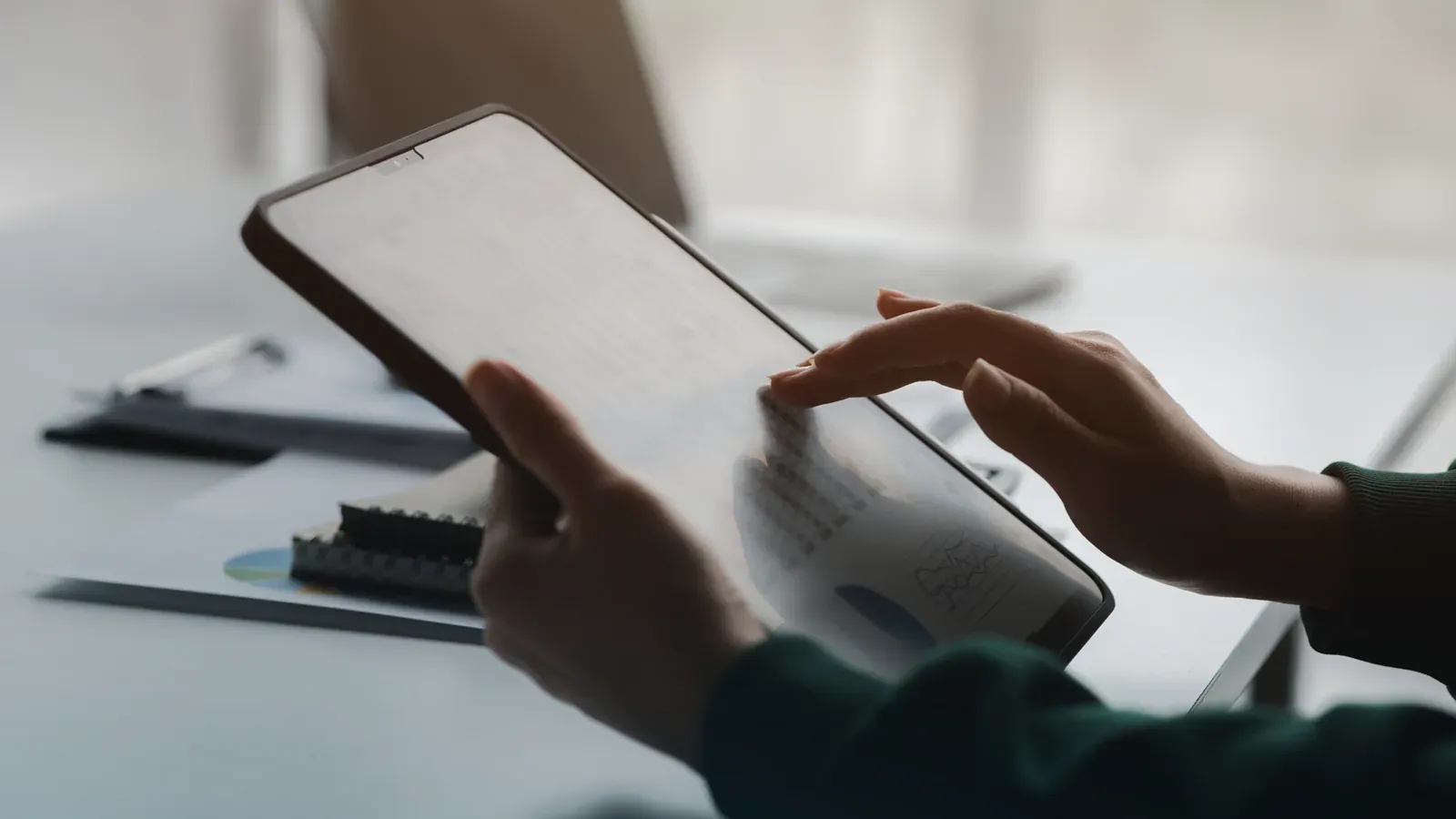 Two people reviewing a document on a tablet across a desk